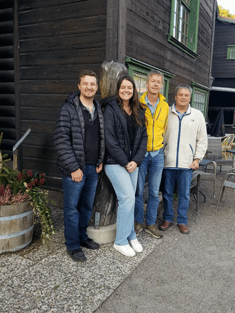 Four people standing in front of a restaurant.