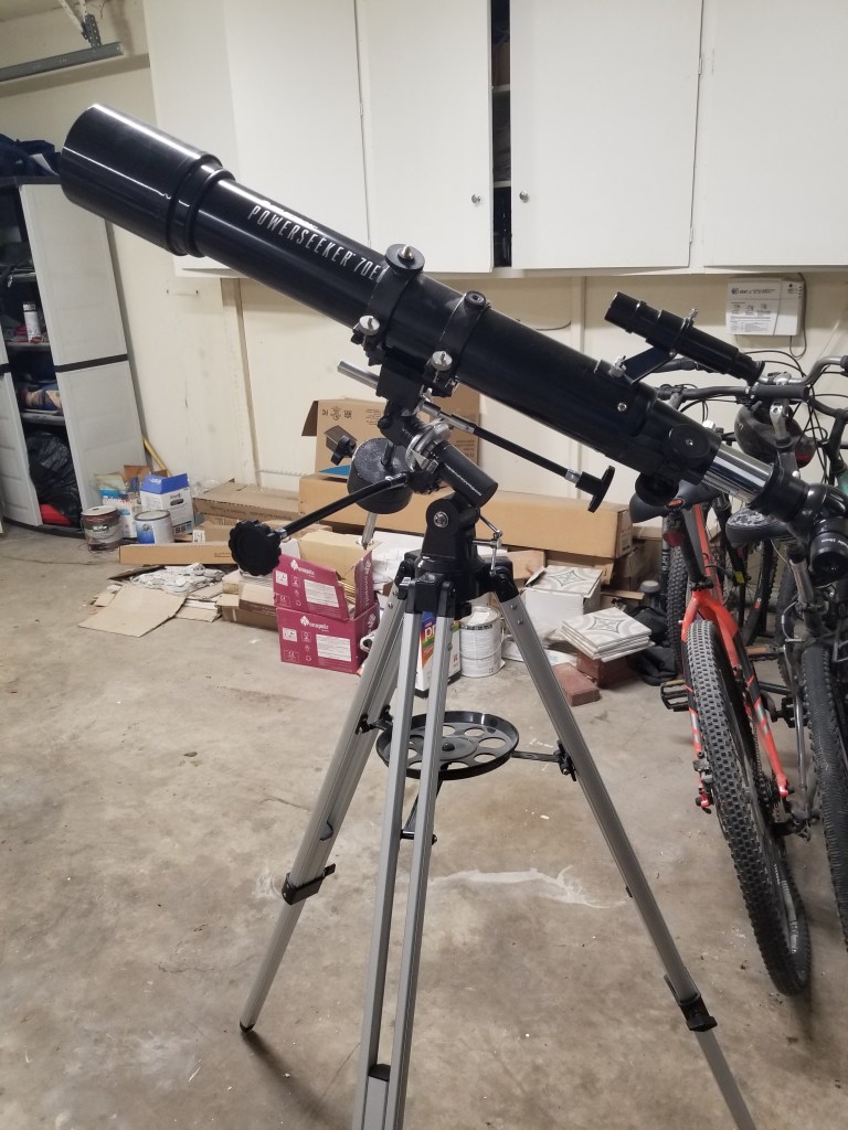 Black Telescope standing in front of bicycles in a garage