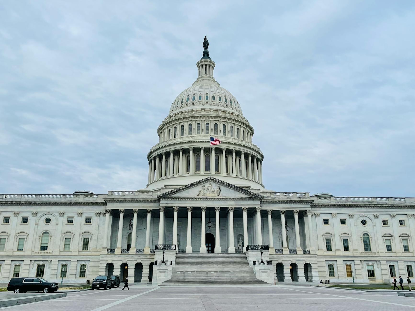 The photo shows the United States Capitol Building, which is white and is shaped like a roundish tower.