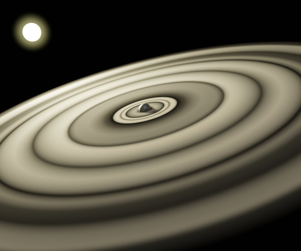 A planet surrounded by rings that are hundreds of times wider than the planet.