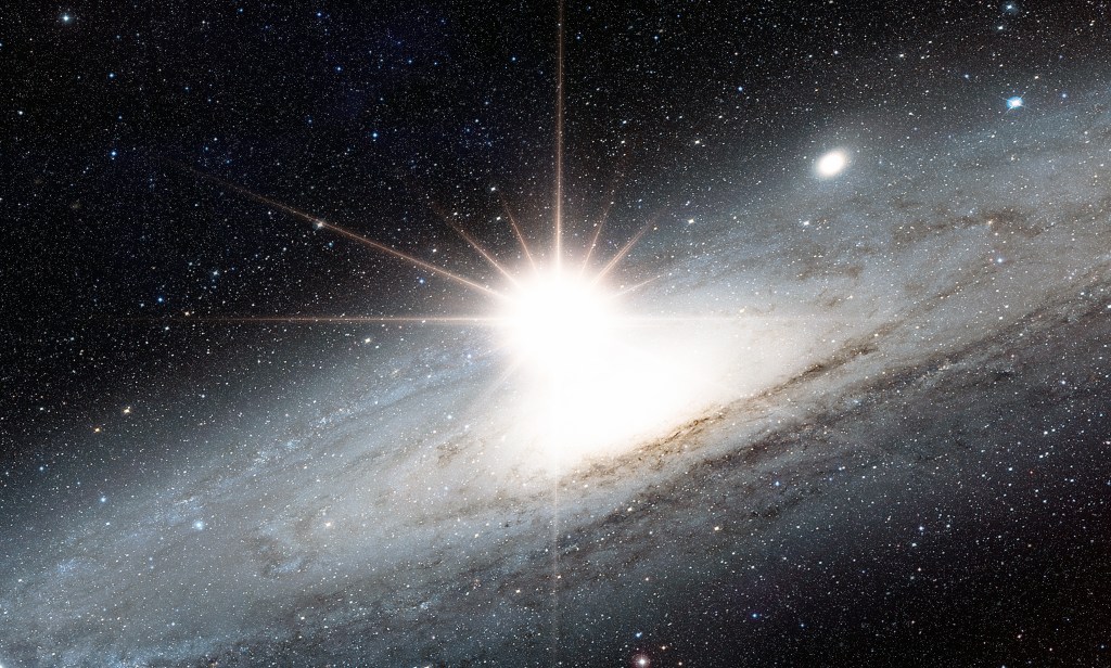 A picture of the Andromeda Galaxy with a bright white light near its center. The bright light is almost outshining the entire galaxy.