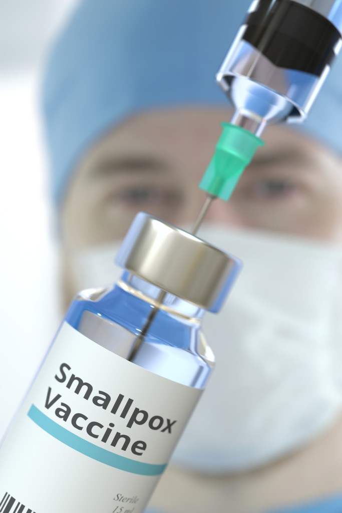 Vial with smallpox vaccine and syringe against blurred doctor's face. 3D rendering | Smallpox Killed 300 million People in the Last Century Before Eradication