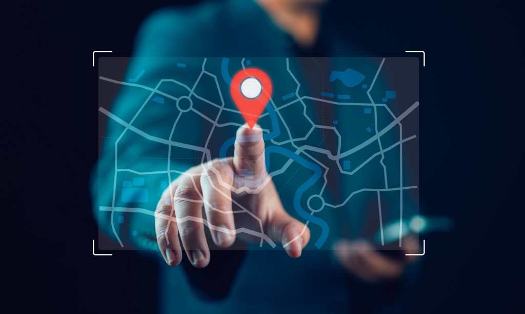 Businessman finger pin for location points and search addresses on the world map application. Marking destination for travel or finding business places in GPS Satellite coordinates system online web | GPS uses relativity for accuracy