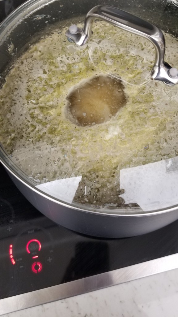 A black pan filled with yellow-beige boiling wort
