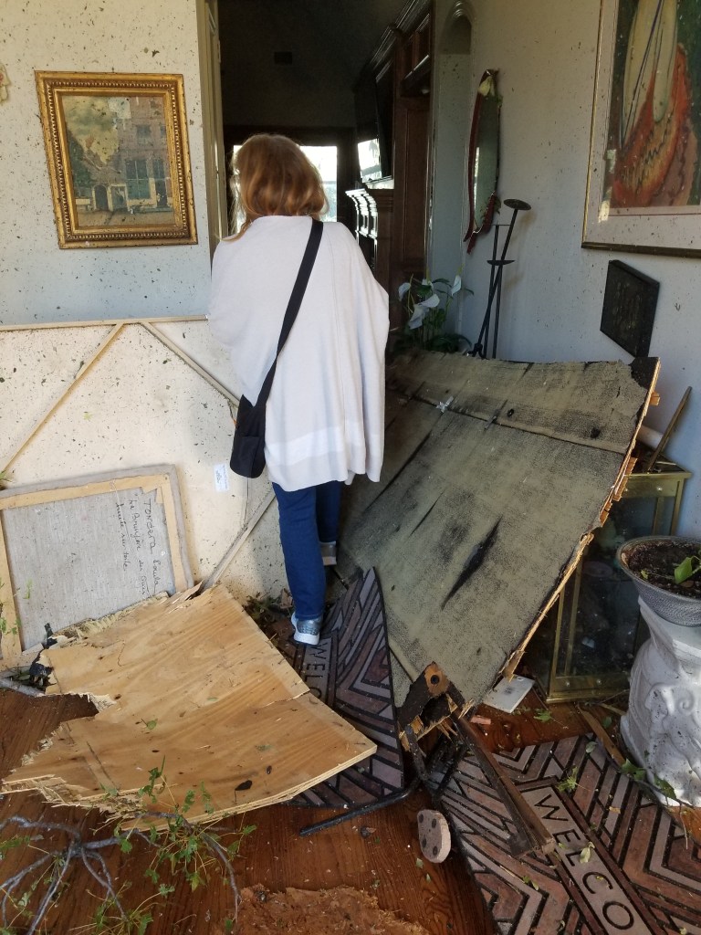 The photo shows my wife Claudia walking into a house with debris everywhere after the EF3 Tornado in Texas.