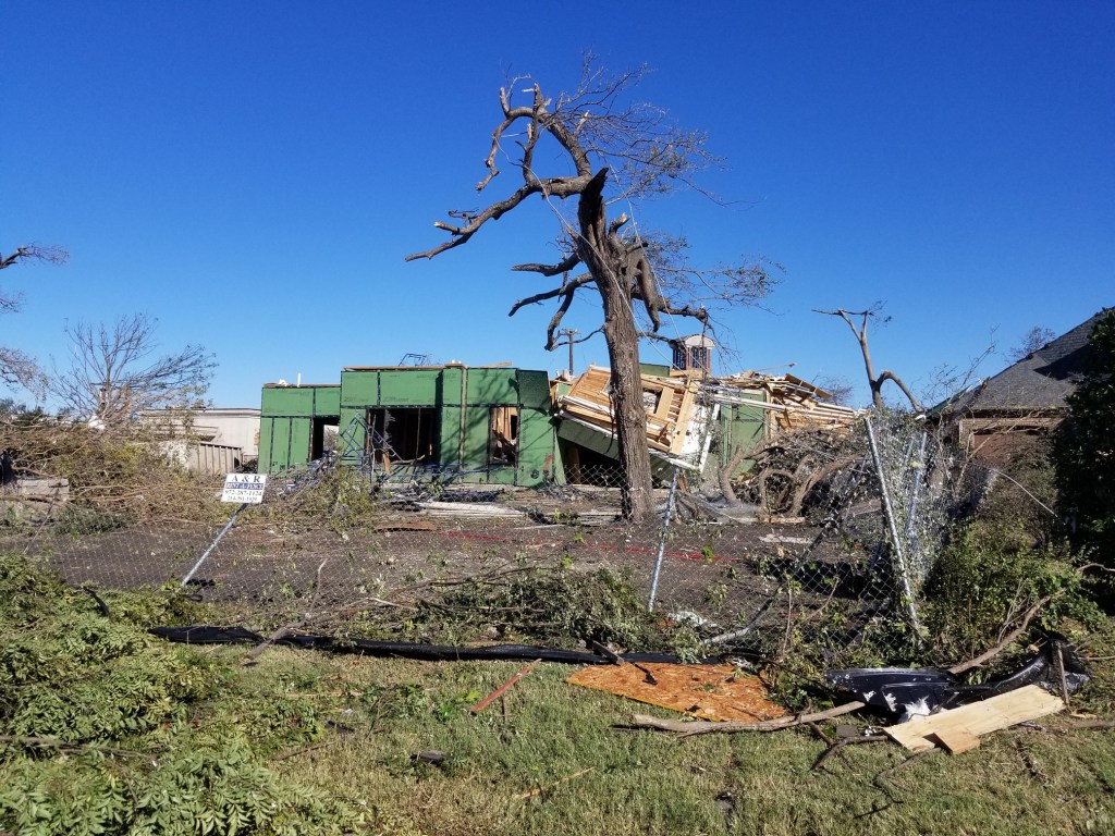 The house is completely flattened. A large tree is destroyed. It has no branches. | United States is Tornado Country