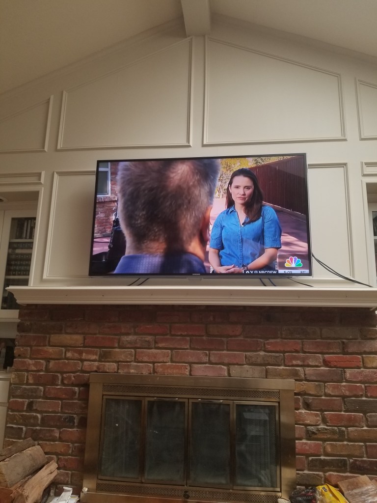 A photo of my TV above the fireplace. I am on the TV screen. | Thomas Wikman NBC Interview 