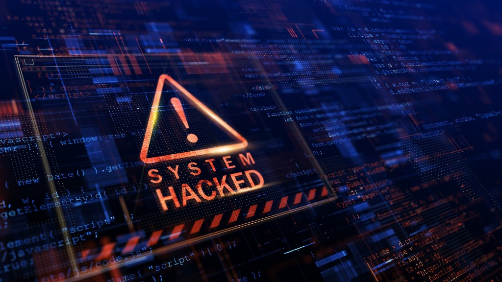 A picture of giant computer screen with a red warning triangle containing an exclamation mark. Underneath the triangle is the text “System Hacked” | More than half of Internet Traffic is Bots