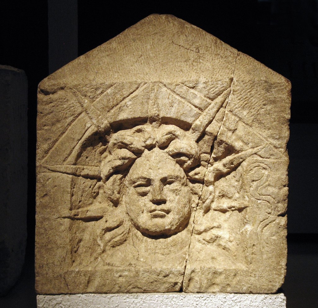 Relief in light brown stone featuring the face of the sun God.