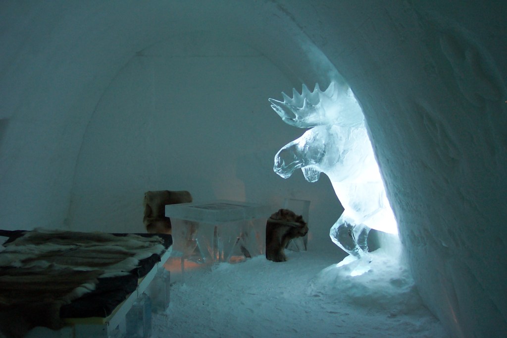 An ice bedroom with an ice statue of a moose.