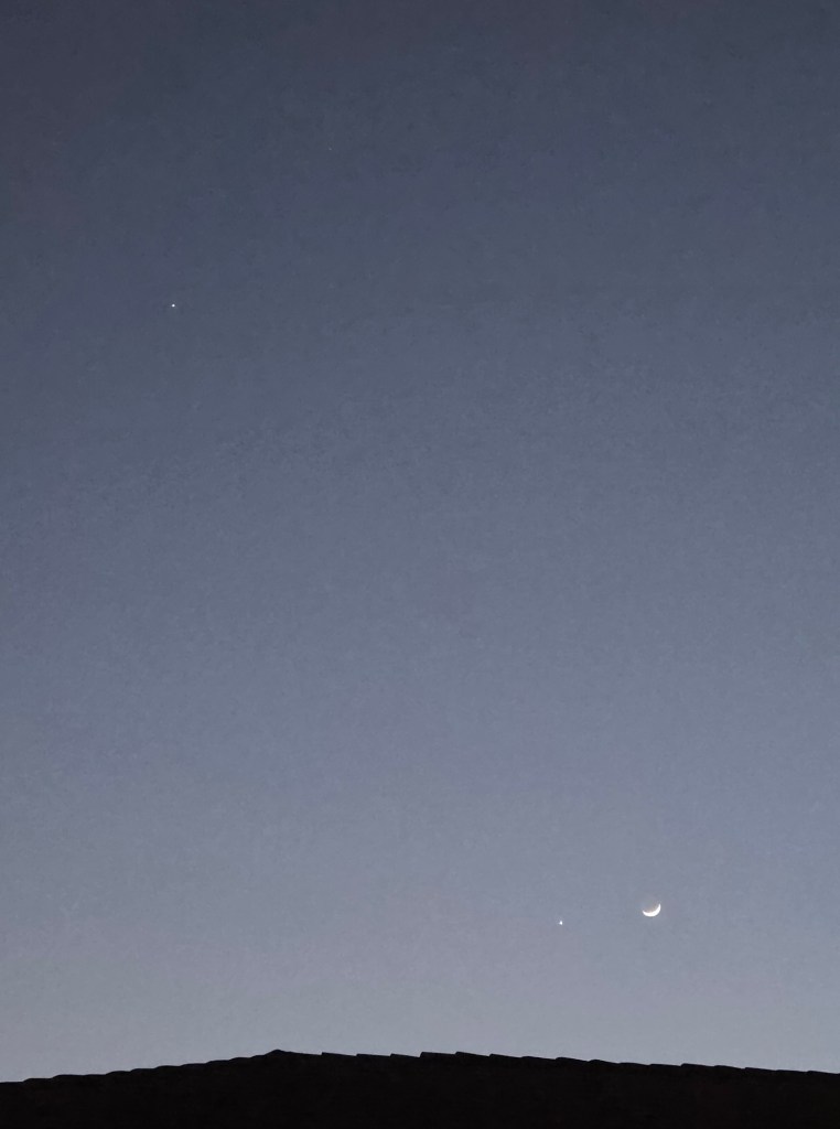 Venus and the crescent moon are in the lower right corner and Jupiter in the upper left corner.