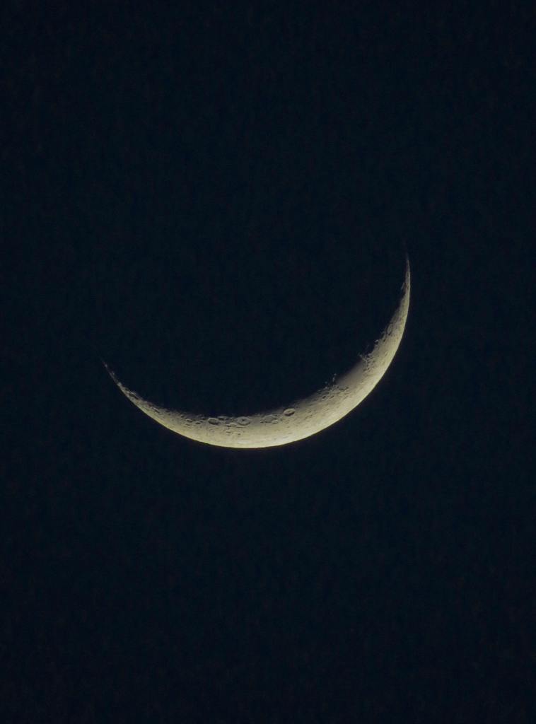 A close up photo of the near side of the moon, but it is a crescent.