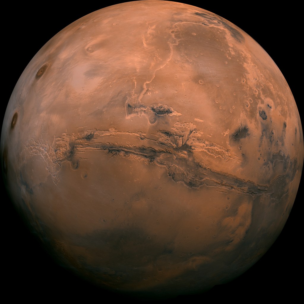 This photo was taken by NASA’s Viking 1 probe in 1976. The photo shows a slightly reddish planet with an enormous canyon, Valles Marineris.